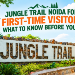 Jungle Trail Noida entrance sign surrounded by colorful bamboo-style poles, owl and parrot sculptures, and lush green plants